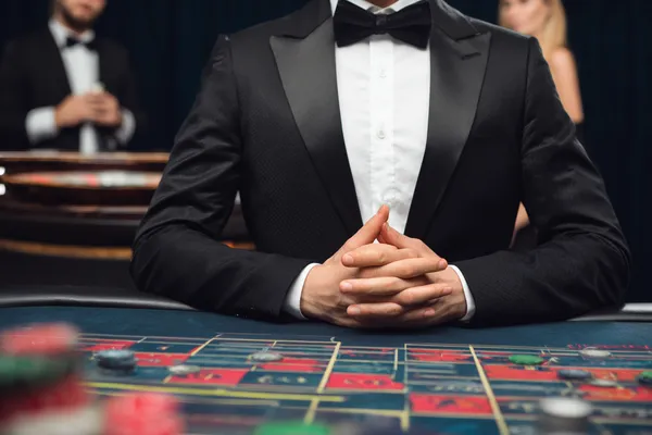 সবুজ বিলাসবহুল গাউন পরা এক নারী অলংকৃত রুলেট চাকার পাশে—যা CROREWIN–এর উচ্চমানের ক্যাসিনো পরিবেশকে প্রকাশ করে।